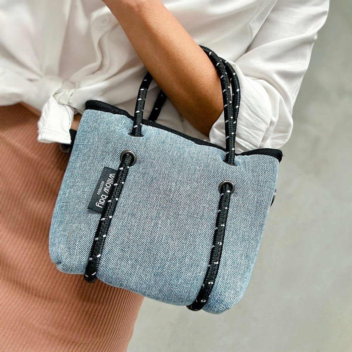 BOUTIQUE TINY Neoprene Tote Bag With Zip - BLUE DENIM-Willow Bay BOUTIQUE TINY Neoprene Tote Bag - Blue Denim The newest addition to the Boutique Family, meet the Tiny! This bag is seriously cool. The perfect companion when needing to store only your essentials. It will comfortably fit your phone, lippy, purse and keys and comes with a cool detachable crossbody strap so it can be used as a cute mini bag and/or a crossbody bag.
The Tiny has the same signature full closure zip as our Boutique and Boutique Mi
