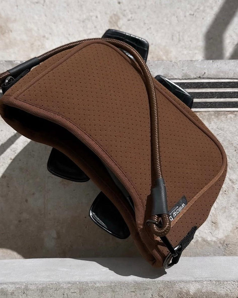 Rust brown perforated baguette bag with a signature rope handle and Willow Bay tag.