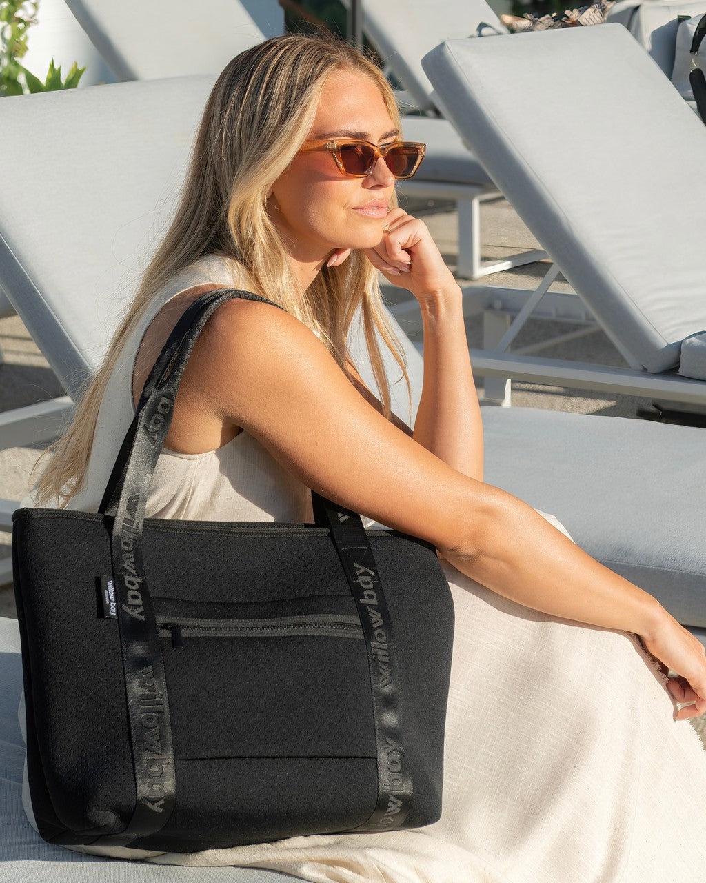 black zippered light weight travel tote bag Away Featherlight in Jet it features a padded sleeve that fits a 16 laptop and travel LeSportsac Black Gray Floral Print