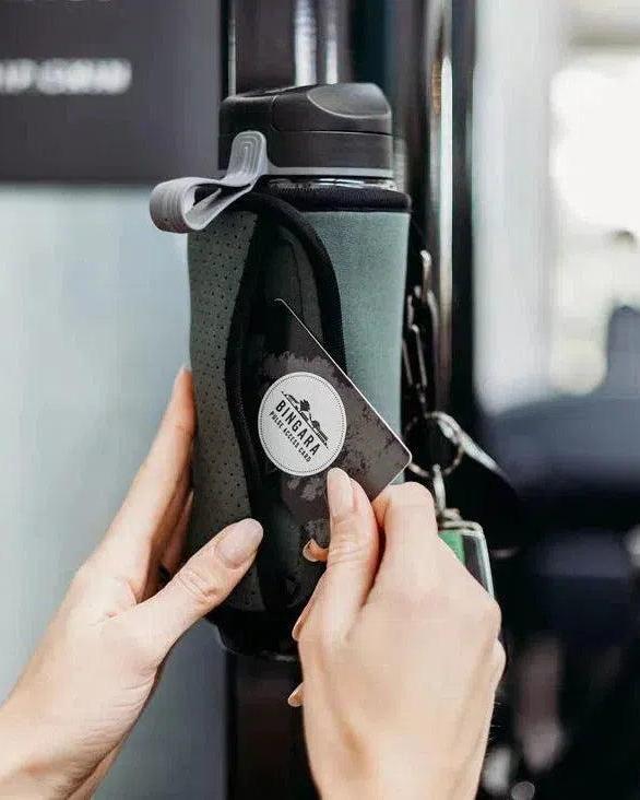 Petrol Magnetic Gym Caddy holding a water bottle and a hand inserting a gym card.
