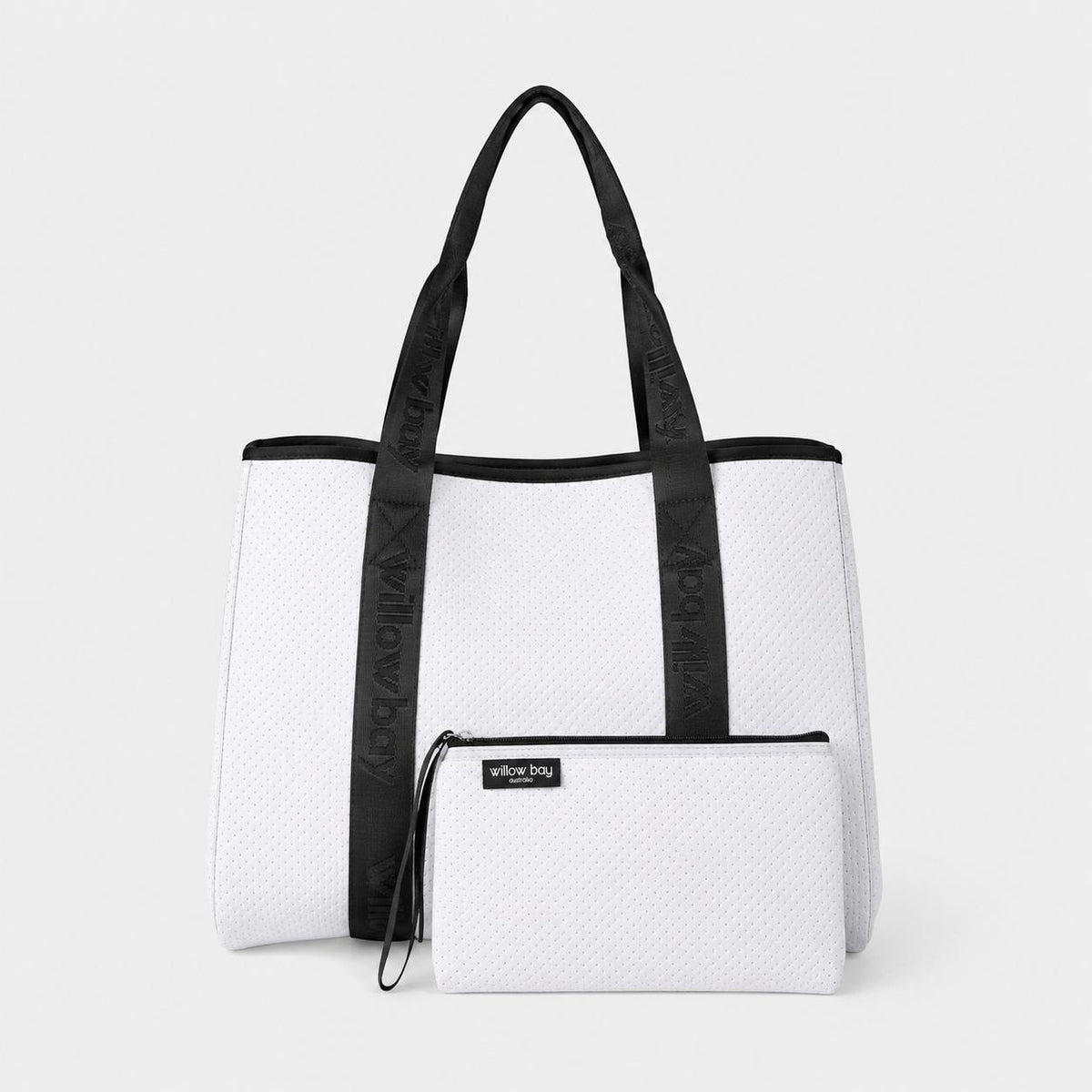 White perforated neoprene tote bag with black branded straps and matching pouch.
